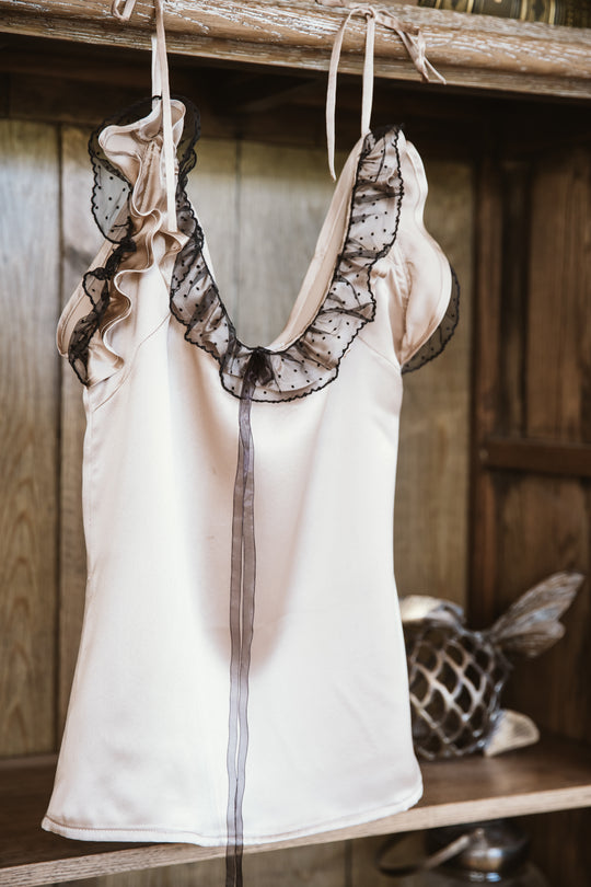  The "Carlina Silk Top," a luxurious and stylish garment. With a silky texture and elegant design, it effortlessly combines modern flair with timeless charm. The Carlina Silk Top is perfect for adding a touch of sophistication and refinement to your look, making it a versatile choice for various occasions.